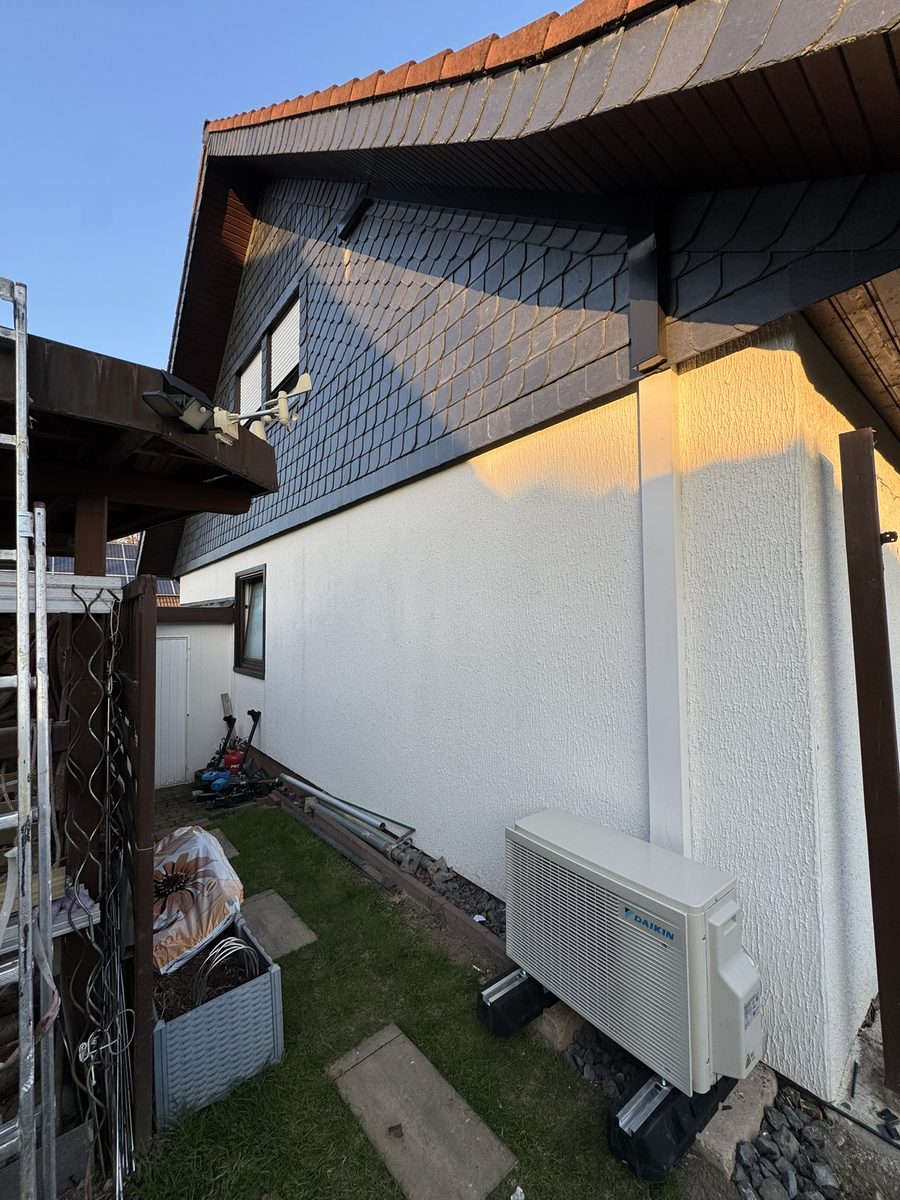 Außengerät an einer Hauswand im Garten